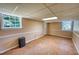 Spacious basement with wood-look flooring, paneled walls, and ample natural light from two windows at 4581 Newcastle Cir, Lithonia, GA 30038
