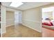 Finished basement area with wood-look flooring, neutral paint, and bedroom with a red quilt at 4581 Newcastle Cir, Lithonia, GA 30038