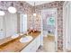 Retro-style bathroom featuring double sinks, vintage wallpaper, pendant lighting, and separate commode at 4581 Newcastle Cir, Lithonia, GA 30038