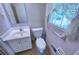 Bathroom featuring toilet, sink, vanity, mirror, window, and towel rack at 4581 Newcastle Cir, Lithonia, GA 30038