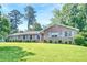 Classic brick home featuring a well-maintained lawn and mature trees, radiating timeless charm at 4581 Newcastle Cir, Lithonia, GA 30038