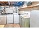 Unfinished basement laundry room with vintage sink and older model washer and dryer appliances at 4581 Newcastle Cir, Lithonia, GA 30038