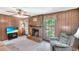 Inviting living room featuring wood paneling, a brick fireplace, and comfortable seating at 4581 Newcastle Cir, Lithonia, GA 30038