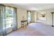 Bright living room with large windows, neutral carpet, and adjacent dining area at 4581 Newcastle Cir, Lithonia, GA 30038