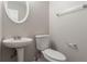 Cozy half bathroom with pedestal sink, oval mirror, and chrome towel rack at 5867 Heritage Walk, Lithonia, GA 30058