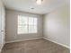 Cozy bedroom featuring a window for natural light and neutral walls with modern carpeting at 5867 Heritage Walk, Lithonia, GA 30058
