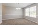 Neutral dining room with chair rail, modern chandelier, neutral walls and carpet at 5867 Heritage Walk, Lithonia, GA 30058