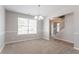 Bright dining room featuring neutral paint, carpet, decorative trim, and a modern light fixture near the stairway at 5867 Heritage Walk, Lithonia, GA 30058