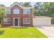 Charming brick two-story home with a well-manicured lawn and attached two-car garage at 5867 Heritage Walk, Lithonia, GA 30058