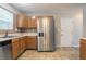 Functional kitchen featuring stainless steel appliances, wooden cabinets, tile backsplash, and tile flooring at 5867 Heritage Walk, Lithonia, GA 30058