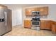 Spacious kitchen showcasing modern stainless steel appliances, wooden cabinets, and tiled flooring at 5867 Heritage Walk, Lithonia, GA 30058