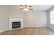 Spacious living room with a decorative fireplace, hardwood floors, a ceiling fan, and plenty of natural light at 5867 Heritage Walk, Lithonia, GA 30058