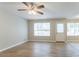 Inviting living room with a ceiling fan, beautiful wood floors, and abundant natural light from multiple windows at 5867 Heritage Walk, Lithonia, GA 30058