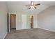 Carpeted main bedroom with a ceiling fan, gray walls, and white trim, showing access to other rooms at 5867 Heritage Walk, Lithonia, GA 30058