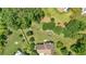 Expansive aerial view of a home showing mature trees, a large yard with a trampoline, and a circular driveway at 1002 Hallman Sw Ter, Marietta, GA 30064