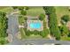 Aerial view of a pool surrounded by trees and lounge chairs, with a gray entrance road at 1002 Hallman Sw Ter, Marietta, GA 30064