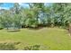 Vast backyard with lush greenery, mature trees, and a trampoline, perfect for outdoor activities at 1002 Hallman Sw Ter, Marietta, GA 30064