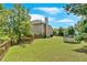 Spacious fenced backyard with an expansive lawn, mature trees, and a trampoline at 1002 Hallman Sw Ter, Marietta, GA 30064