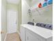 Bright laundry room features a white washer and dryer set and storage shelf at 1002 Hallman Sw Ter, Marietta, GA 30064