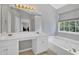 Bright bathroom features a large vanity with dual sinks, soaking tub, and access to the bonus room at 1002 Hallman Sw Ter, Marietta, GA 30064