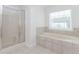 Bright bathroom featuring a soaking tub, tile surround, and a glass door shower at 2023 Jameson Cir, Lawrenceville, GA 30043