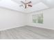 Bedroom featuring gray wood flooring, tray ceiling, ceiling fan, and natural light at 2023 Jameson Cir, Lawrenceville, GA 30043