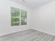 Bedroom with large window providing natural light and gray wood flooring at 2023 Jameson Cir, Lawrenceville, GA 30043