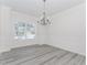 Bright dining room featuring gray wood flooring, elegant chandelier, and wainscoting at 2023 Jameson Cir, Lawrenceville, GA 30043