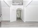 Bright foyer with soaring ceilings, gray wood floors, wainscoting, and an arched doorway, leading to the living spaces at 2023 Jameson Cir, Lawrenceville, GA 30043