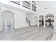Spacious living room with loft, staircase, gray wood floors, leading to entry, kitchen, and multiple rooms at 2023 Jameson Cir, Lawrenceville, GA 30043
