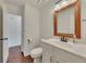 Bright bathroom features a wooden-framed mirror, white vanity, and modern fixtures at 2031 Greyfield Nw Dr, Kennesaw, GA 30152