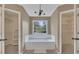 Bathroom with chandelier, tub, large tub window, and two walk-in closets at 2031 Greyfield Nw Dr, Kennesaw, GA 30152