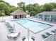A pool area with sun chairs, tables and umbrellas, tennis court and covered seating at 2031 Greyfield Nw Dr, Kennesaw, GA 30152