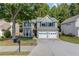 Charming home showcasing a well-maintained lawn, mature tree, and a convenient two-car garage at 3485 Parkbrooke Ln, Duluth, GA 30096