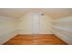 Unfinished attic space with hardwood floors, wire shelving, and a gable window at 1006 Arbor Ne Trce, Atlanta, GA 30319