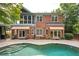 Brick home features a backyard pool and patio area with mature landscaping, offering a private outdoor retreat at 1006 Arbor Ne Trce, Atlanta, GA 30319