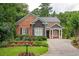 Charming brick home featuring lush landscaping, a well-manicured lawn, and a brick driveway at 1006 Arbor Ne Trce, Atlanta, GA 30319