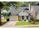 Charming single-Gathering home with a yellow door, a well-manicured lawn, and an attached one-car garage at 1334 Gates Se Dr, Atlanta, GA 30316