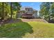 Expansive backyard featuring a well-maintained lawn and mature trees; partial view of the home at 2713 Misty Rock Cv, Dacula, GA 30019