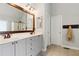 This bathroom offers double sinks, gray cabinetry, tan tile flooring and a large framed mirror at 2713 Misty Rock Cv, Dacula, GA 30019