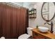 Powder room featuring brown vanity and shower curtain with dark fixtures and decor at 2713 Misty Rock Cv, Dacula, GA 30019
