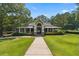 Inviting community clubhouse with a covered porch, lush landscaping, and mature trees at 2713 Misty Rock Cv, Dacula, GA 30019