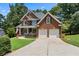 Traditional two-story brick home with an attached garage and well-maintained driveway at 2713 Misty Rock Cv, Dacula, GA 30019