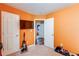 Vibrant room with orange walls, multiple doors, and a glimpse into the hallway at 1574 Leonard St, Hampton, GA 30228