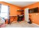 An orange bedroom offering ample space, including a mounted television and ironing equipment at 1574 Leonard St, Hampton, GA 30228