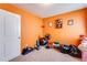 An orange bedroom featuring carpeted floors and ample space for a workout area at 1574 Leonard St, Hampton, GA 30228