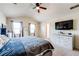 Comfortable bedroom with bright windows, ceiling fan, carpet, and a TV for relaxation at 1574 Leonard St, Hampton, GA 30228