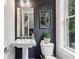Elegant powder room with a pedestal sink, dark accent wall, and decorative artwork at 1821 Huntington Hills Nw Ln, Atlanta, GA 30309