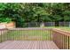 View of a wooden deck overlooking a fenced backyard with mature trees, offering privacy and a serene outdoor space at 421 River Trace Dr, Villa Rica, GA 30180