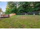 Spacious backyard featuring a wooden deck, fire pit, and mature trees, fully fenced for privacy and security at 421 River Trace Dr, Villa Rica, GA 30180